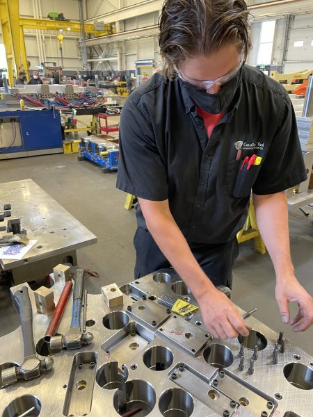 Young Tool Making Leader Mark Walton working on various mold components.